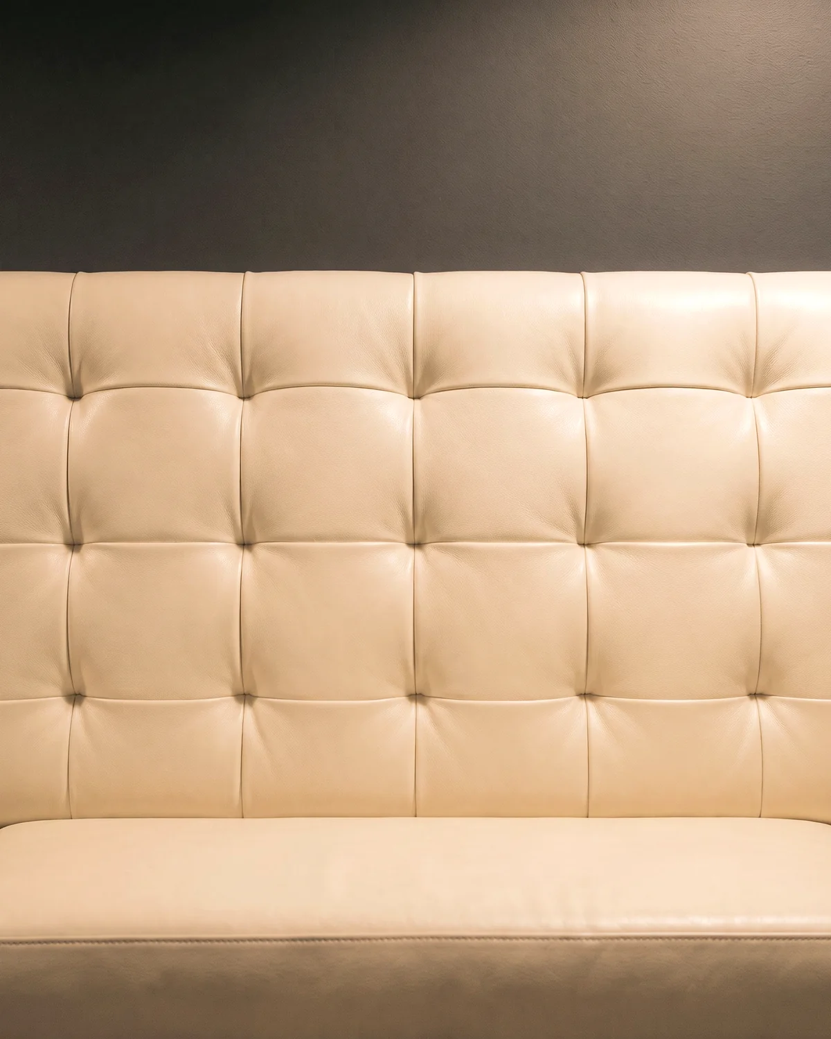 An ivory leather square-tufted booth back