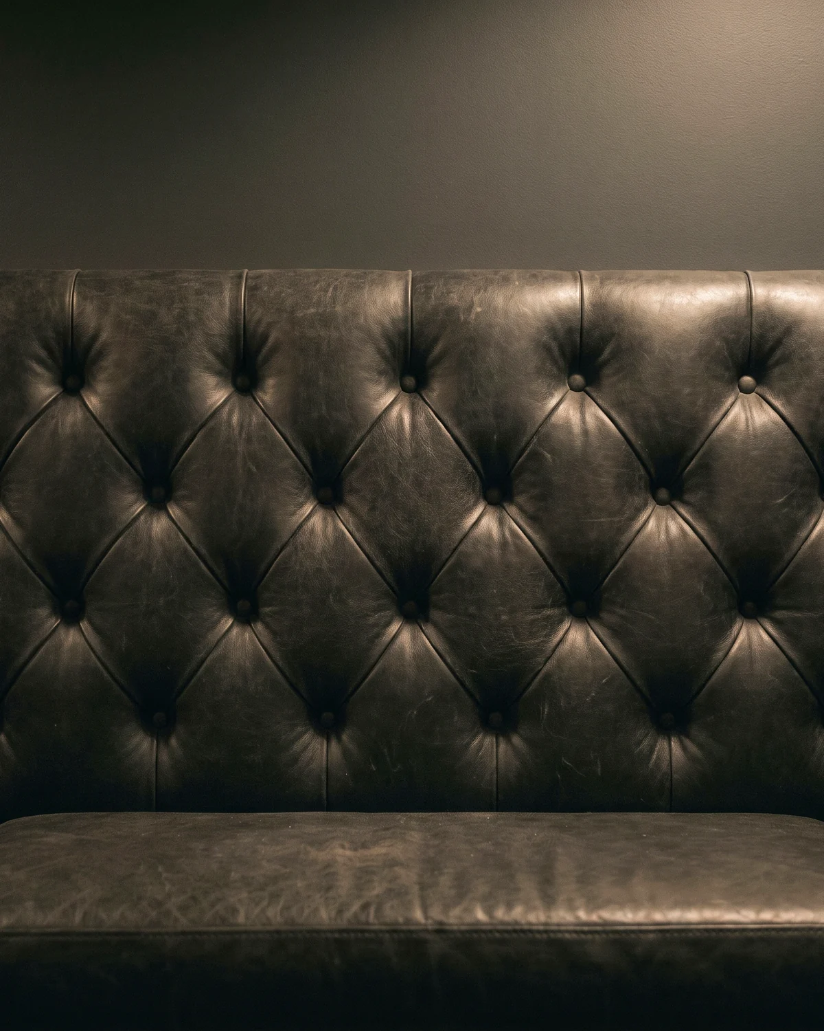 A black leather diamond-tufted booth back